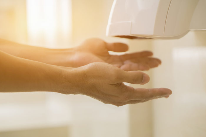 Trocknen der Hände mit einer Trocknungsmaschine, anstatt mehr Keime zu verbreiten